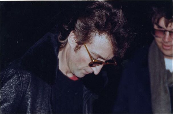 Джон Леннон биография. Джон Леннон и Йоко Оно. Джон Леннон смерть. На заднем плане убийца Джона Марк Чепмэн. 8 декабря 1980 г.